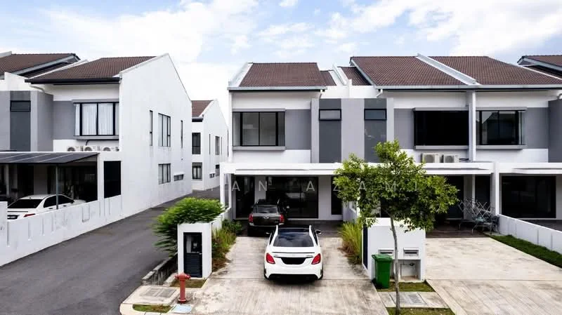 Exterior type: linked terrace house; features: white painted facade, grey accent walls, pitched tile roof, two-storey structure, manicured lawn, driveway with interlocking pavers, car porch with awning, surrounded by mature greenery, parking space for multiple vehicles, visible street access; style: modern.