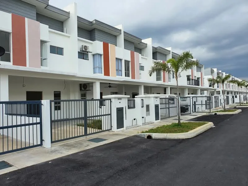 Exterior type: linked terrace house; features: white painted facade, horizontal grey cladding, vertical red accent panels, gated entrance, manicured lawn, paved driveway, multiple air conditioning units visible, covered porch area, two-storey structure, surrounded by greenery; style: modern.