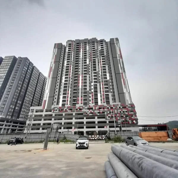 Exterior type: high-rise condominium; features: grey and red facade, glass curtain wall, recessed balconies, multiple storeys, concrete structure, surrounded by construction materials, open-air parking area; style: modern.