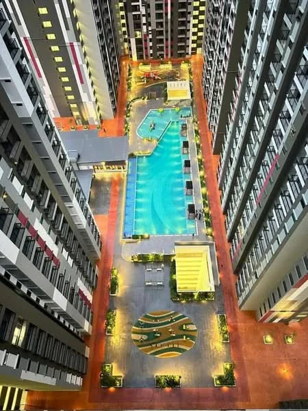 Exterior type: high-rise condominium; features: infinity pool, pool deck with loungers, landscaped garden area, children's playground, outdoor dining pavilion, water features, surrounding high-rise buildings, night lighting, manicured landscaping; style: modern.