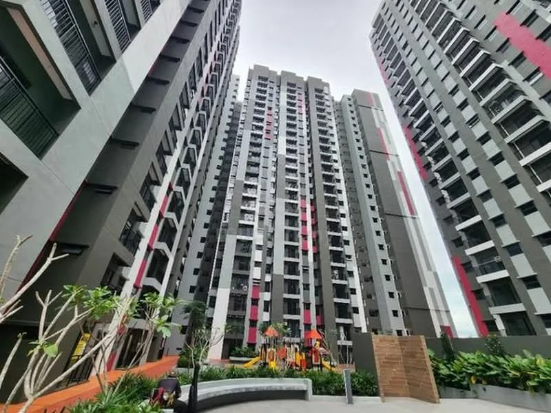 Exterior type: high-rise condominium; features: modern facade with grey and red accents, multiple storeys, balconies on upper floors, landscaped garden area, children's playground visible, manicured landscaping with plants, outdoor seating area, surrounding walkways; style: modern.