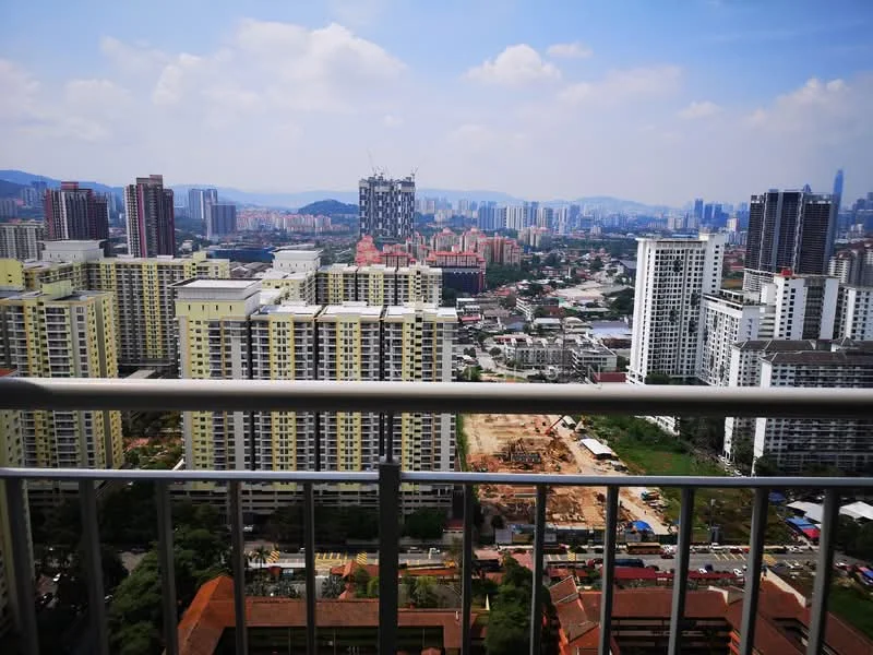 Exterior type: high-rise condominium; features: city skyline view, surrounded by urban development, multiple high-rise buildings, construction site visible, greenery in foreground, clear blue sky, balcony railing in foreground; style: modern.