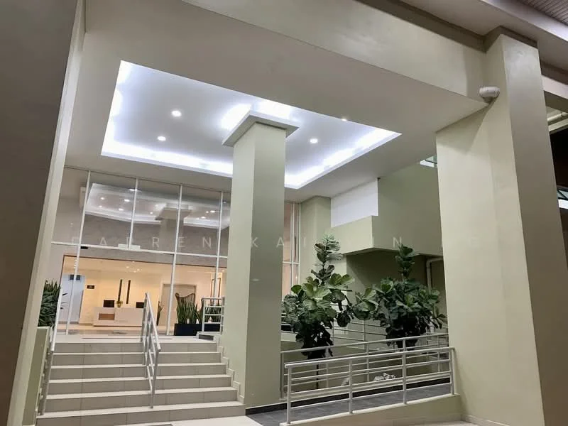Exterior type: low-rise apartment block; features: glass entrance doors, staircase with handrails, potted plants, recessed lighting in ceiling, smooth painted walls in light green, wide entrance area, modern architectural design; style: modern.