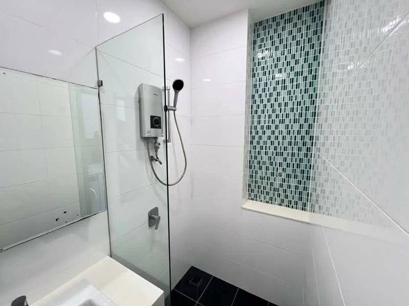 Bathroom features: glass shower enclosure, rain shower head, handheld shower, white tiled walls, accent wall with mosaic tile, black floor tiles, single-sink vanity, mirror above sink, chrome faucet, built-in shower niche; style: modern.