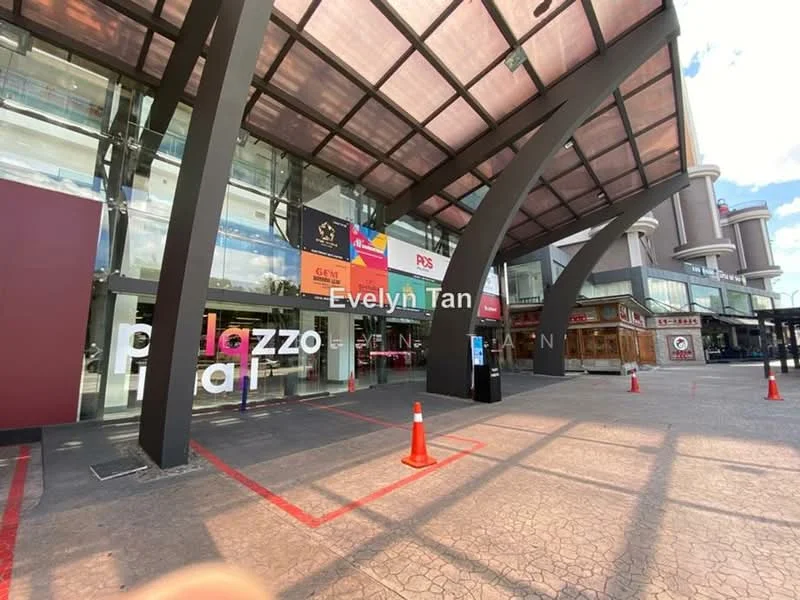 Exterior type: commercial building; features: glass facade, metal awning, entrance with large glass doors, red and white signage, paved walkway, parking cones, overhang structure, surrounding retail shops; style: modern.