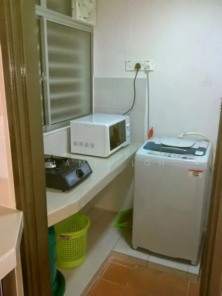 Laundry features: white washing machine, microwave, grey countertop, green laundry basket, tile flooring, white tiled walls, window with horizontal slats, plug socket on wall.