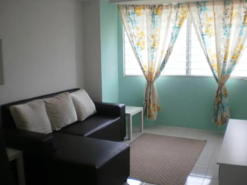 Living features: black leather sofa with chaise, three beige throw pillows, light green painted walls, white tiled flooring, window with horizontal slats, sheer curtains with floral pattern, small white side table, white TV console, area rug with neutral color; style: modern.