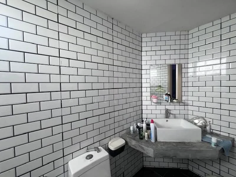 Bathroom features: white subway tile walls, grey marble countertop, single-bowl sink, chrome basin mixer faucet, framed mirror, one-piece toilet, black tile flooring, various toiletries on countertop; style: modern.