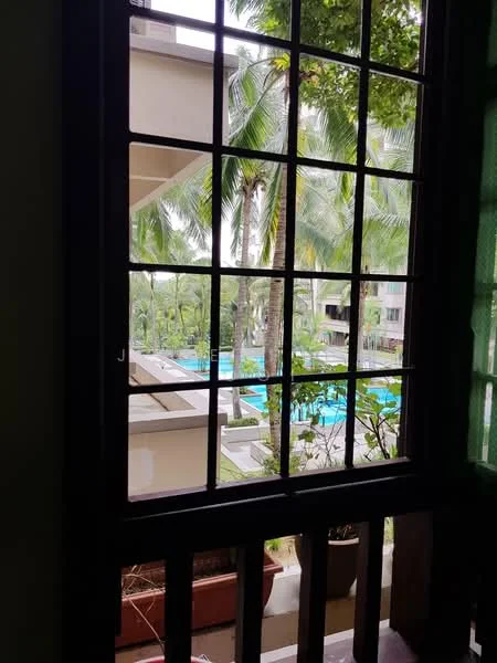 Room features: window with grid design, green curtains, view of swimming pool, view of palm trees, view of landscaped garden, potted plants on balcony; view: pool.