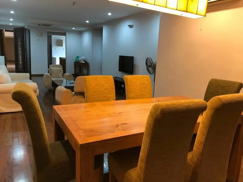 Dining features: wooden dining table, 6 upholstered dining chairs, recessed downlights, wooden flooring, wall-mounted TV, ceiling fan, decorative wall light; style: modern. Living features: fabric sofa in white, coffee table, TV console, wall-mounted TV, wooden flooring; style: modern.