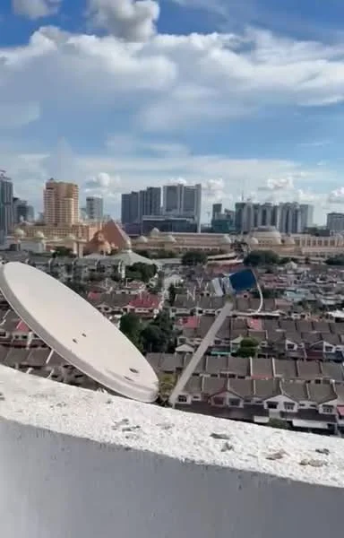 Exterior features: city skyline view, satellite dish, rooftop, urban landscape, mixed-use buildings, residential rooftops, clear blue sky, clouds; style: modern.