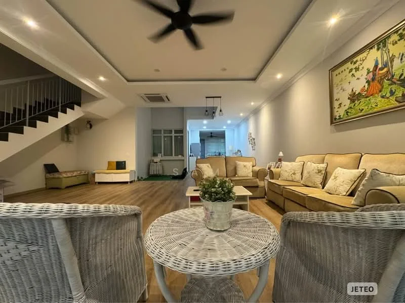Living features: wooden flooring, white painted walls, tray ceiling, 5-blade ceiling fan with light, sofa with beige upholstery, coffee table with woven design, decorative artwork on wall, large windows with natural light, area rug with geometric pattern, potted plant on coffee table, side seating area with cushions; style: contemporary.