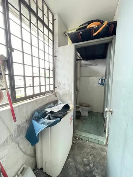 Laundry features: washing machine, window with metal grille, grey painted walls, tile flooring, exposed plumbing, utility sink, storage shelves, cluttered space. Bathroom features: toilet, white tiled walls, green tiled flooring, small window, exposed plumbing.
