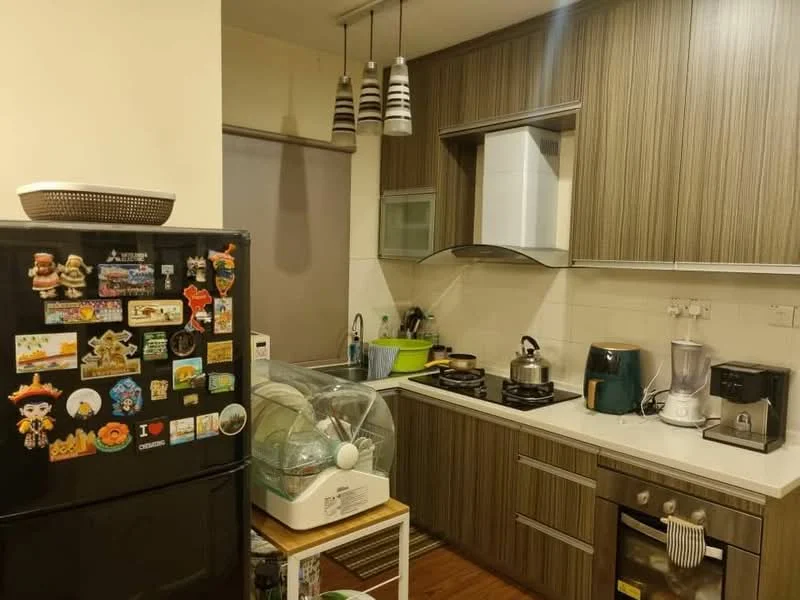 Kitchen features: brown wooden cabinetry, white countertop, stainless-steel sink, chrome pull-down faucet, built-in oven, freestanding gas range oven, black fridge with magnets, blender, kettle, microwave, pendant lighting, green dish rack, wooden flooring; style: modern.