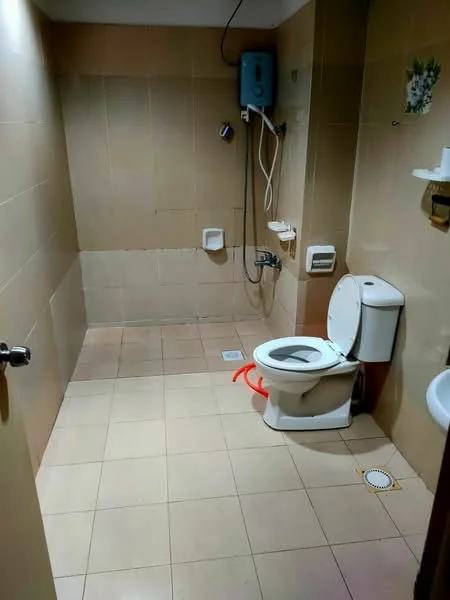 Bathroom features: cream tiled walls, cream tiled flooring, one-piece toilet, shower with wall-mounted faucet, handheld shower, toilet paper holder, soap dish, sink with faucet, water heater, mirror, drain in floor.