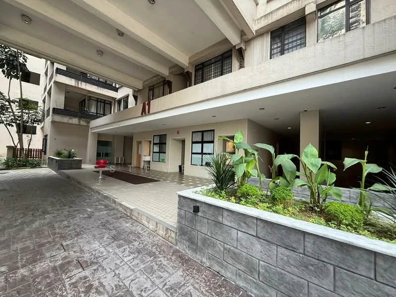 Exterior type: low-rise apartment block; features: covered entrance area, paved walkway, landscaped garden with plants, large windows, multiple levels visible, concrete facade, outdoor seating area, open-air corridor; style: modern.