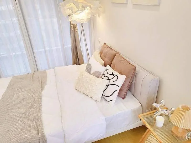 Bedroom features: queen-size bed, upholstered headboard, decorative pillows in various colors, light grey throw blanket, floor lamp with unique design, wooden side table, glass top on side table, silver bedside lamp, floor-to-ceiling windows with sheer curtains, wooden flooring; style: modern.