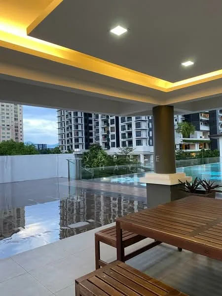 Exterior type: swimming pool deck; features: outdoor seating area with wooden table, glass railing, reflected surface on the floor, modern lighting fixtures, surrounding high-rise buildings, manicured landscaping, swimming pool visible in the background; style: modern.