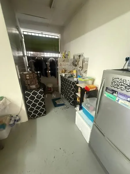 Laundry features: grey concrete flooring, stainless-steel fridge, white cabinetry, black patterned storage bins, sink with faucet, clothes hanging rack, window with green blinds, various cleaning supplies, plastic containers, broom and mop.