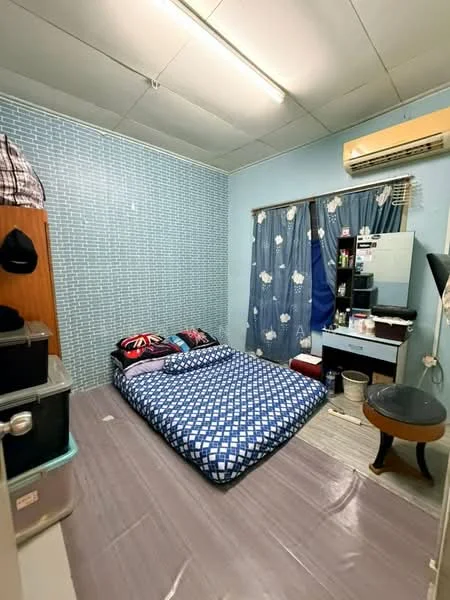 Bedroom features: blue painted walls, checkered bedspread, single bed, window with blue curtains, wall-mounted air conditioning unit, wooden wardrobe, dressing table with mirror, plastic storage containers, plastic flooring, ceiling lights.