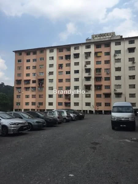 Exterior type: low-rise apartment block; features: pink and cream painted facade, multiple balconies, ground-level parking area, surrounding greenery, asphalt parking lot, windows with metal grilles; style: modern.