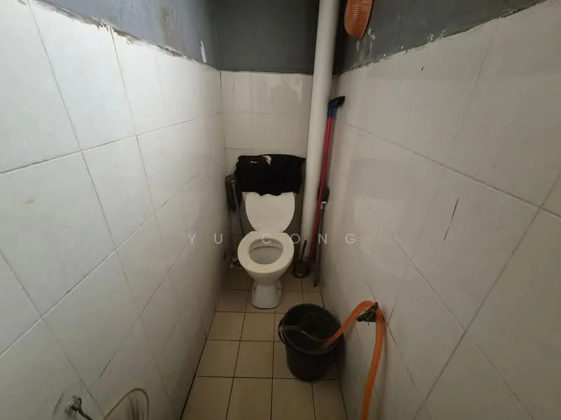Bathroom features: white tiled walls, cream tiled flooring, one-piece toilet, toilet paper holder, cleaning supplies, bucket, plumbing pipe, broom, wall-mounted shelf.