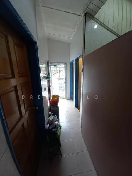 Room features: tiled flooring, white walls, wooden door, blue door frames, staircase visible, cleaning supplies in corner, natural light from window, open layout; style: minimalist.