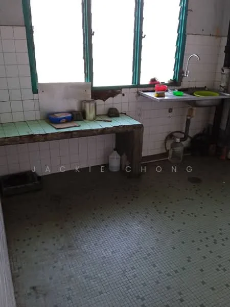 Kitchen features: green window frames, white tiled walls, green tiled countertop, wooden workbench, sink with faucet, visible plumbing, mosaic tile flooring, natural light from windows.