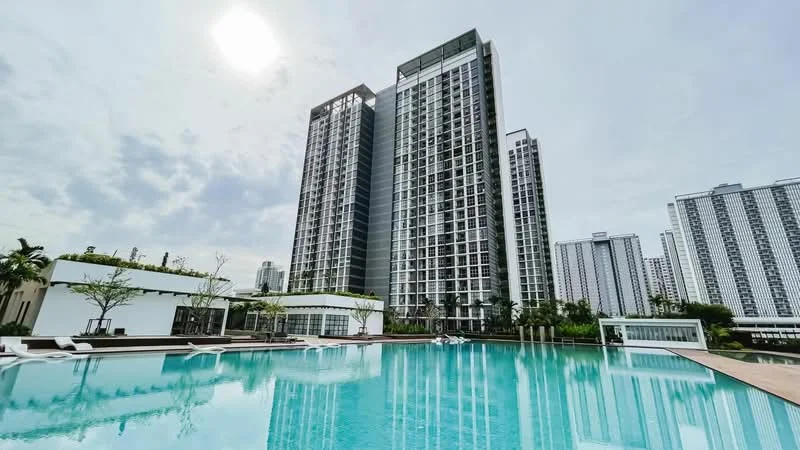 Exterior type: high-rise condominium; features: infinity pool, pool deck with loungers, landscaped gardens, glass curtain wall facade, multiple high-rise buildings, surrounded by greenery, sunny sky, modern architectural design; style: modern.