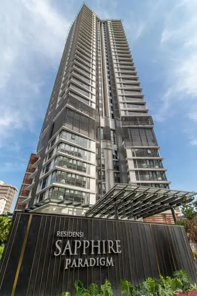 Exterior type: high-rise condominium; features: glass curtain wall, projecting balconies, feature lighting at night, manicured landscaping, modern facade, entrance canopy, signage with building name, surrounded by urban context; style: modern.