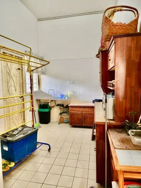 Kitchen features: white tiled walls, ceramic tile flooring, wood cabinetry, double-bowl stainless-steel sink, chrome pull-down faucet, countertop with wooden finish, open shelving, laundry rack, green trash bin, blue storage container, basket on top of cabinet.