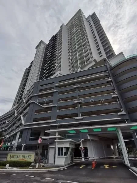 Exterior type: high-rise condominium; features: glass curtain wall, grey painted facade, multiple balconies, security guard house at entrance, covered parking, multi-storey car park, porte cochère drop-off, feature lighting at night; style: modern.