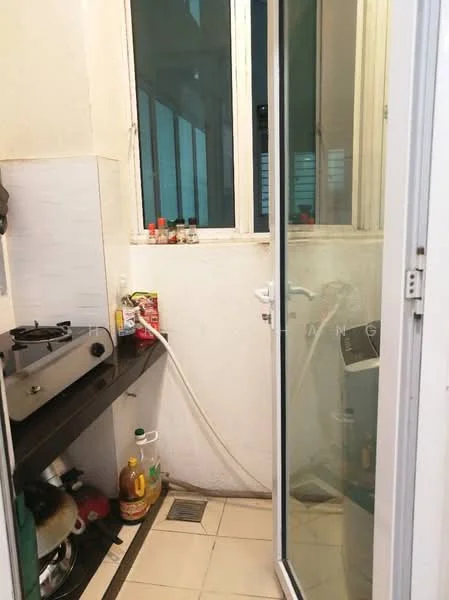 Room features: white painted walls, ceramic tile flooring, single glass door, window with multiple panes, black countertop, gas stove, kitchen utensils visible, bottle of cooking oil, various spice containers, sink with drainage, washing machine visible.
