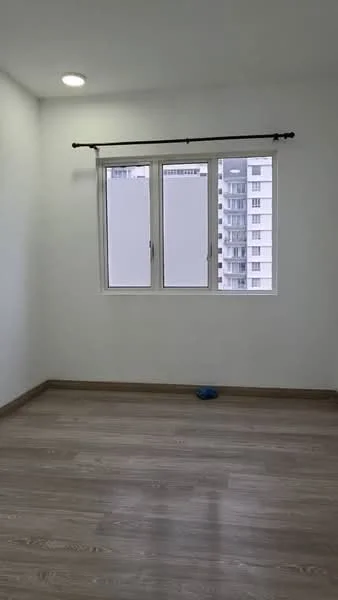 Room features: white painted walls, laminate flooring, floor-to-ceiling windows, curtain rod, natural light from window, neutral color scheme, no visible furniture, minimal decor; style: modern; view: city.