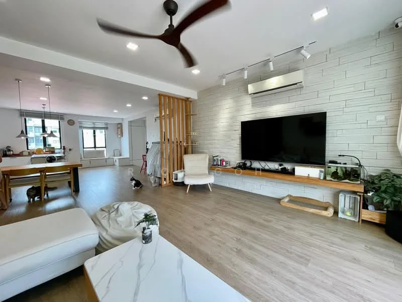 Living features: light wood flooring, exposed brick accent wall, large wall-mounted TV, white media console, recessed LED downlights, 5-blade ceiling fan, large windows with natural light, decorative plants, open-plan layout, sofa with light upholstery, coffee table with marble top, wooden shelving unit, dining area visible in background; style: modern.