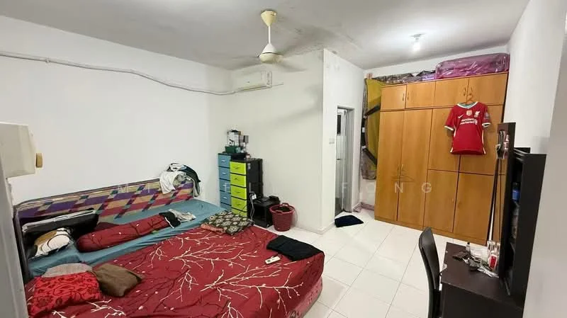 Bedroom features: white painted walls, tile flooring, ceiling fan, double bed with red bedding, single bed with blue bedding, built-in wardrobe with wooden finish, TV console, wall-mounted TV, green dresser, laundry basket, clothing on beds.