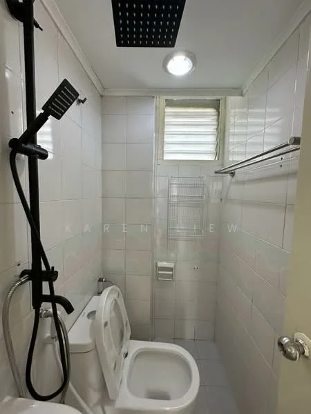 Bathroom features: white tiled walls, white tiled flooring, one-piece toilet, handheld shower, rain shower head, chrome basin mixer, wall-mounted towel rack, window for ventilation, ceiling light.