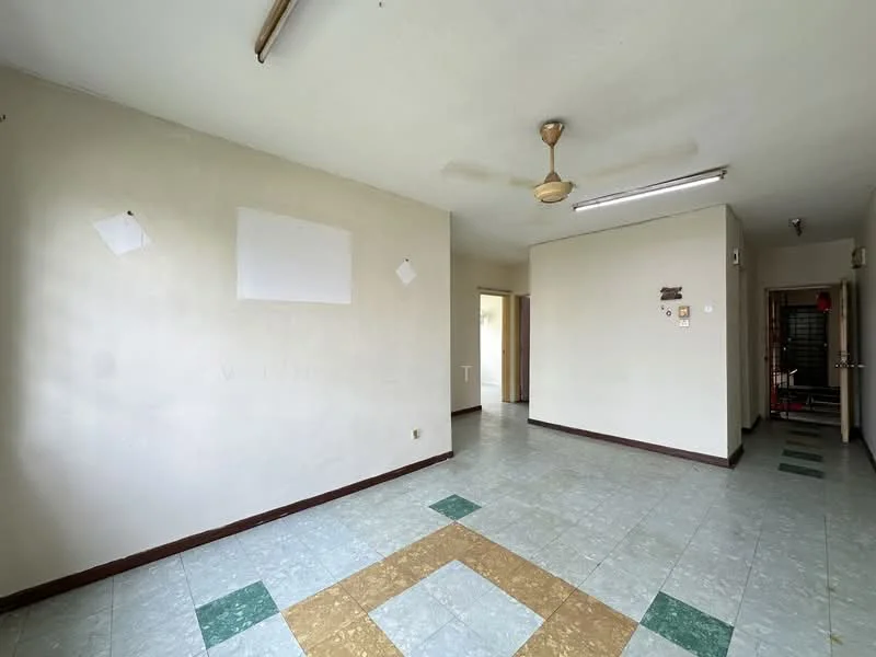 Room features: cream painted walls, ceiling fan, fluorescent ceiling lights, vinyl flooring in green and beige, open layout, doorway leading to another room, wall-mounted electrical outlets, no visible furniture.
