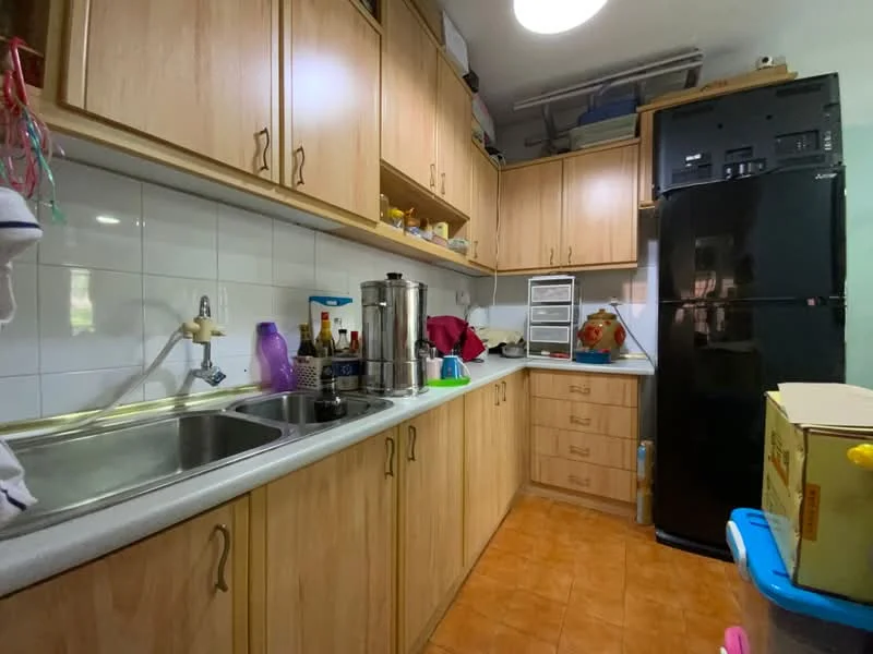 Kitchen features: laminate cabinetry in light wood finish, double-bowl stainless-steel sink, chrome pull-down faucet, white tiled backsplash, grey countertop, built-in refrigerator in black, oven, kitchen storage drawers, orange ceramic tile flooring, overhead lighting, open shelving, various kitchen appliances, kitchen utensils, countertop with clutter; style: modern.