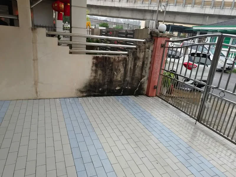 Exterior type: linked terrace house; features: paved flooring with blue and grey tiles, metal gate, concrete wall with visible stains, surrounding greenery, driveway, car parking area; style: modern.