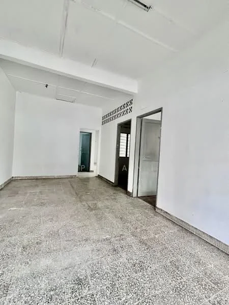 Room features: white painted walls, exposed ceiling, grey terrazzo flooring, doorway leading to another room, window with metal grille, open space layout, no visible furniture, natural light from window; style: minimalist.