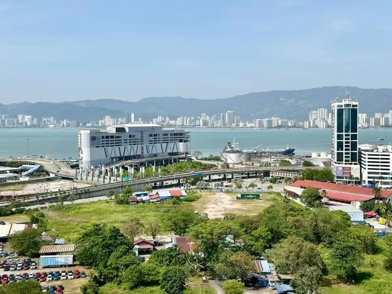 Exterior type: high-rise condominium; features: city skyline view, waterfront location, surrounded by greenery, multi-storey building, commercial buildings nearby, open parking area, road access, urban landscape; style: modern.