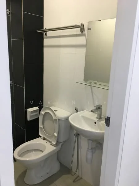 Bathroom features: white ceramic toilet, single-sink vanity with chrome faucet, mirror above sink, glass shelf above sink, black tiled wall, white painted walls, grey tile flooring, towel bar, shower area, plumbing visible under sink; style: modern.
