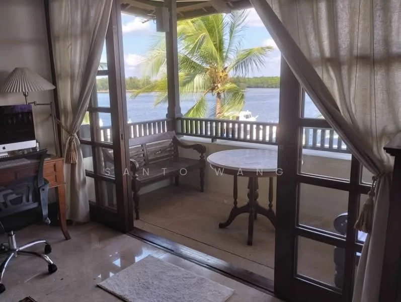 Room features: wooden flooring, large glass sliding doors, sheer curtains, wooden bench, round dining table, palm tree view, decorative rug, desk with chair; style: modern; view: water.