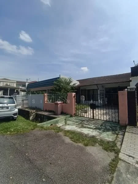 Exterior type: semi-detached house; features: single-storey, pink painted facade, metal roof, front garden with grass, fenced yard, driveway with interlocking pavers, car parked in driveway, mature tree in front yard, paved walkway, gated entry; style: modern.