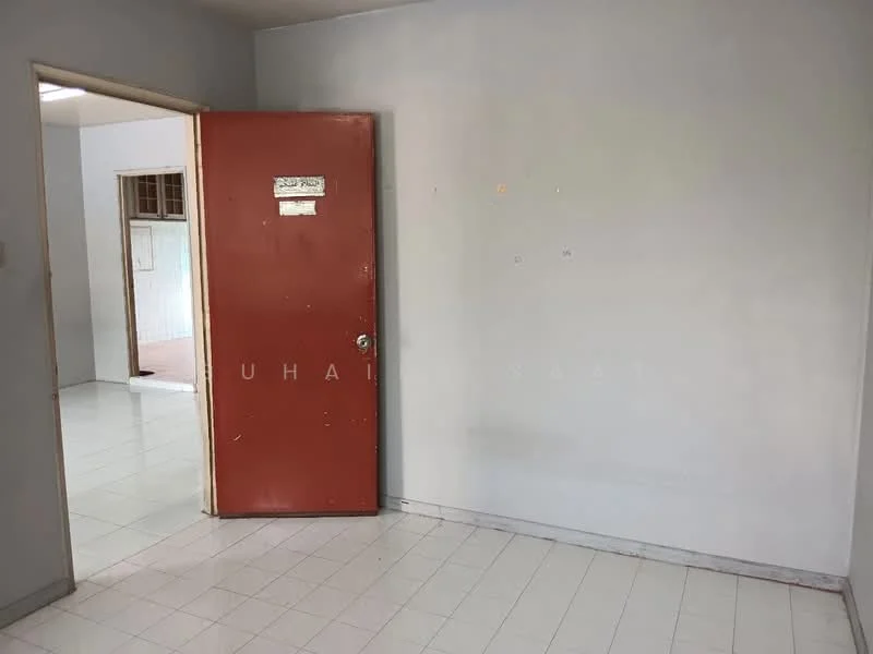Room features: white painted walls, white tile flooring, red door, door handle, light switch, empty wall space.