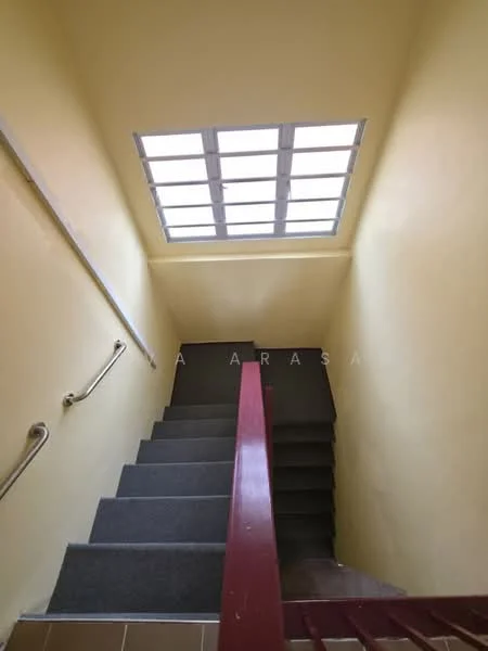 Room features: yellow painted walls, grey stair treads, handrail on the left, skylight above, concrete stairs, tile flooring at the bottom, natural light from skylight.