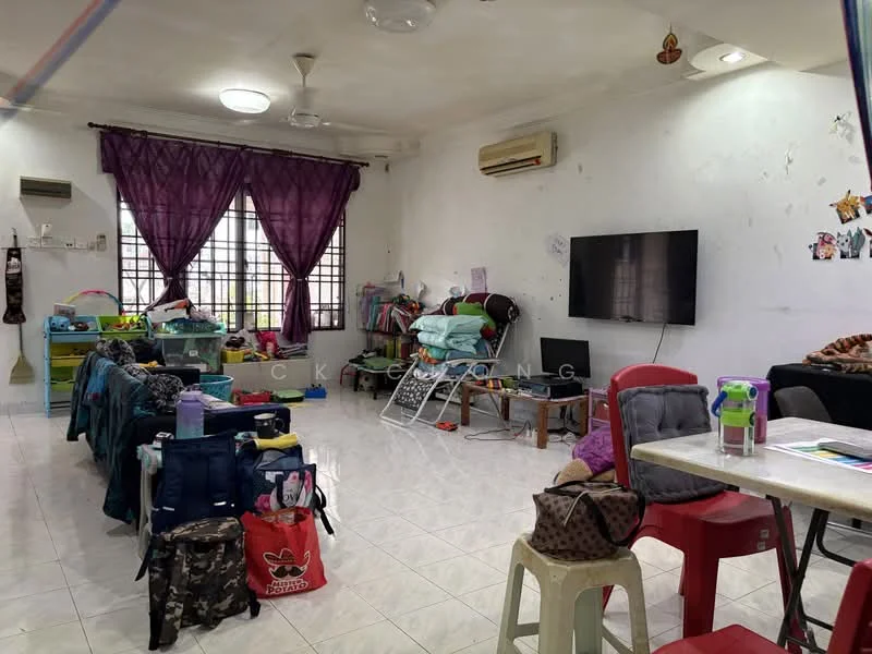 Living features: white painted walls, tiled flooring, 2 wall-mounted split AC units, 5-blade ceiling fan, large windows with sheer curtains, wall-mounted TV, sofa, dining table with chairs, laundry rack, various storage items, decorative wall art, multiple bags and personal items.
