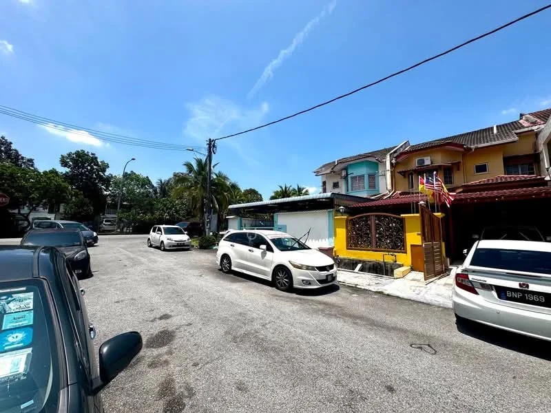 Exterior type: linked terrace house; features: yellow painted facade, two-storey building, front gate with decorative design, paved driveway, surrounded by palm trees, street view with parked cars, clear blue sky; style: traditional.
