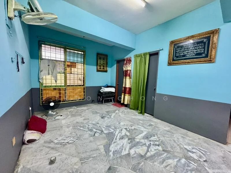 Room features: blue painted walls, grey painted accent wall, marble tile flooring, ceiling fan, window with metal grille, curtains in green, framed artwork on wall, stack of folded towels.